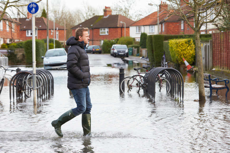 A man walking through a flooded street.