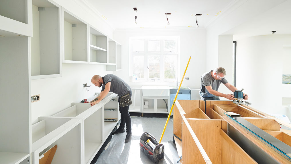 Tradesmen install a new kitchen.