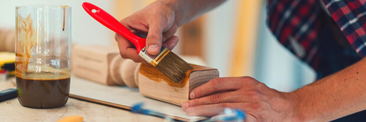 Man varnishing a piece of wood