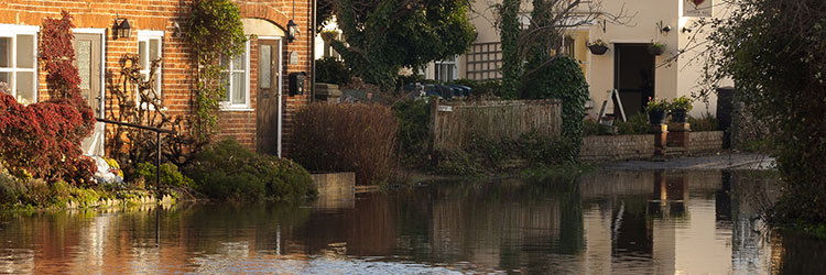 Flooded village road with white and brown houses